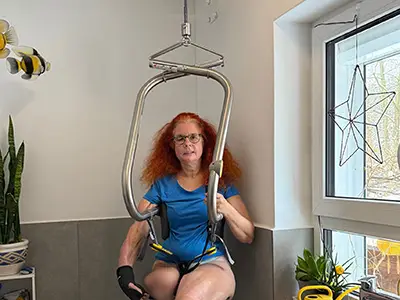 Beate situt im Hebebügel im Bad