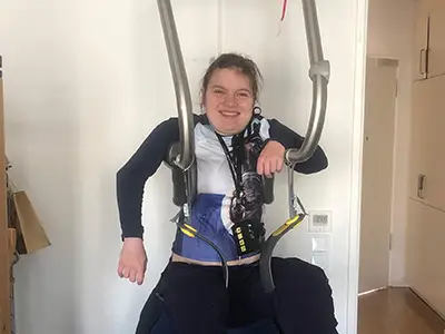 Nadin sitzt im Hebebügel und lacht in die Kamera